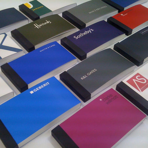 A collection of branded notebooks with colorful covers arranged