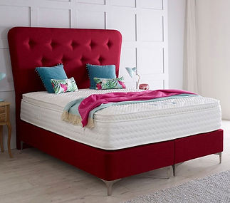 Red upholstered bed with a plush headboard features a white mattress
