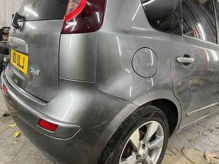 Close-up of a shiny silver car's rear side in a garage