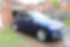 Side view of a glossy blue Audi SUV after a professional car wash