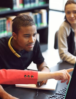 Three students collaborating on a computer, focused on their work