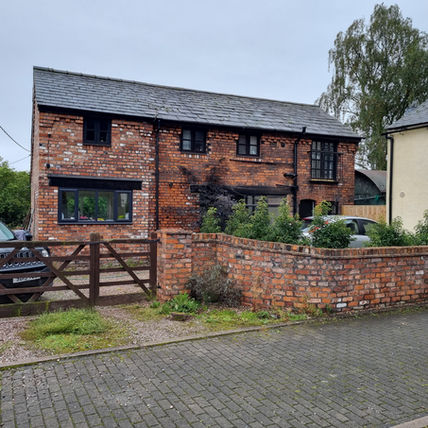 rustic two-story brick house with gravel drive