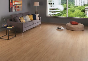 A modern living room with a gray sofa, colorful cushions, floor lamp, and abstract art