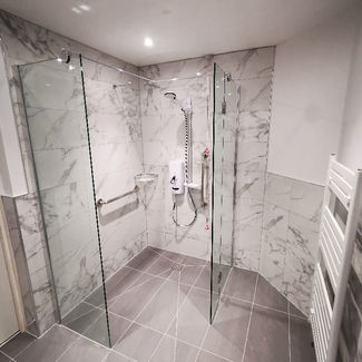 Luxury walk in shower with marble effect wall tiles and glass enclosure