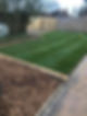 Freshly laid sod on a rectangular lawn bordered by wooden edges