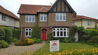 A two-story house with a red door and red-tiled roof