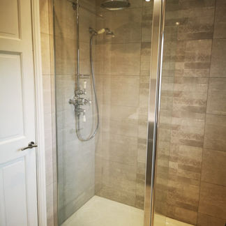 Frameless glass shower enclosure with contemporary wall tiling