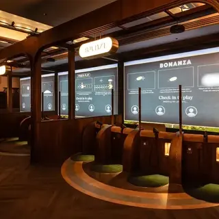 A stylish indoor golf venue with modern, sleek booths