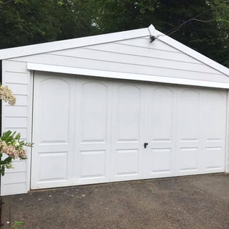 White garage with double doors on a concrete driveway