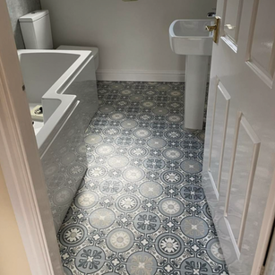 A small bathroom with white fixtures, including a bathtub, toilet, and pedestal sink