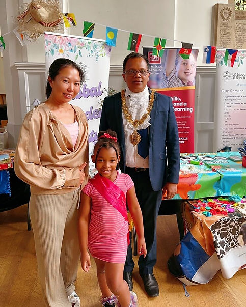 A family stands in front of colourful banners and tables at a event