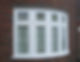 Brick house with a white bay window, featuring five vertical panels