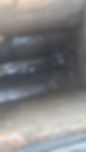 A close-up of a greasy, rusted metal surface inside a confined space