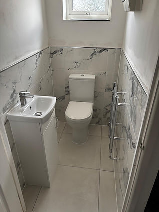 A small, modern bathroom with marble-patterned tiles