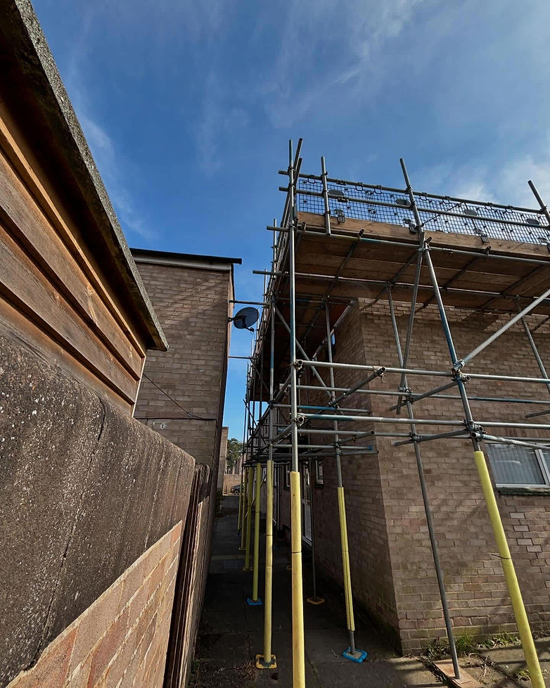 Brick houses under construction with metal scaffolding