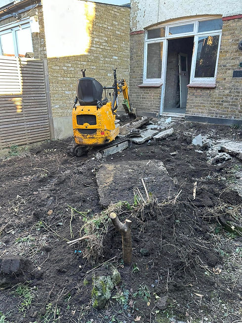 A small yellow excavator sits on broken concrete