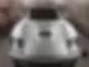 A silver sports car is parked in a garage with soft lighting