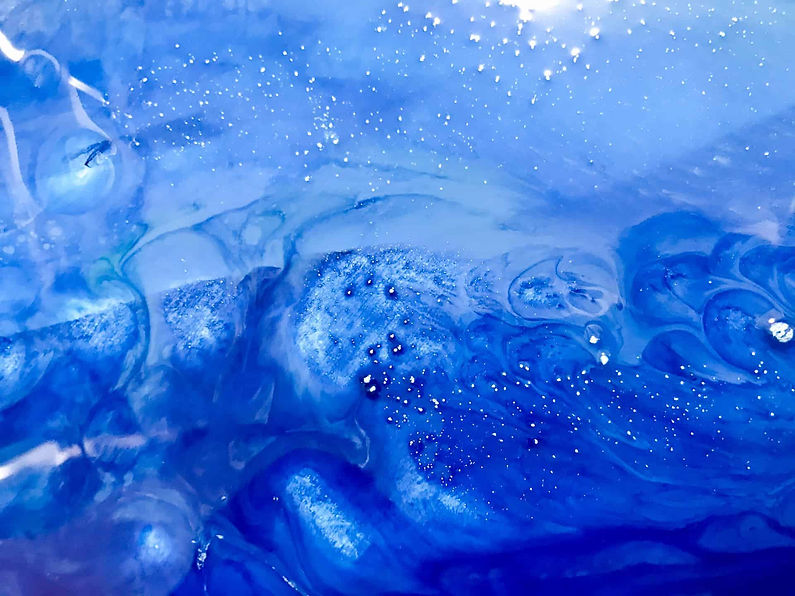 Abstract image with swirling blue hues and white specks, resembling an ocean or night sky