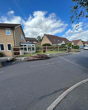 Front yard with wooden fence under construction outside a suburban house