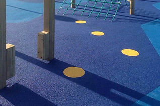 Playground with blue rubber flooring, yellow circular patterns