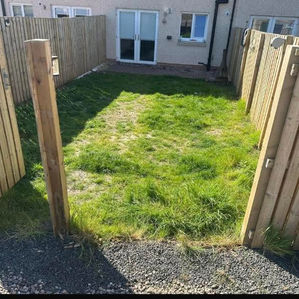 Enclosed rear garden with a small patch of grass and wooden boundary fencing