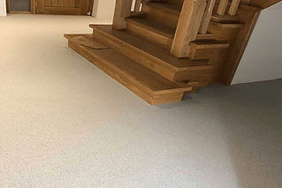 Elegant wooden staircase with light carpeted floor
