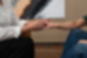 Two people hold hands in a supportive gesture