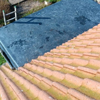 View from a rooftop showing orange tiles in the foreground, a flat dark rooftop section in the middle