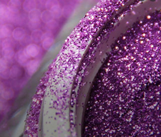 Close-up of vibrant purple glitter in a container