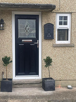 Front door with geometric glass panels on a textured wall