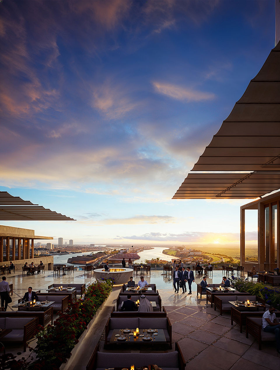 Outdoor luxury terrace and lounge area overlooking a scenic harbor during a golden sunset.