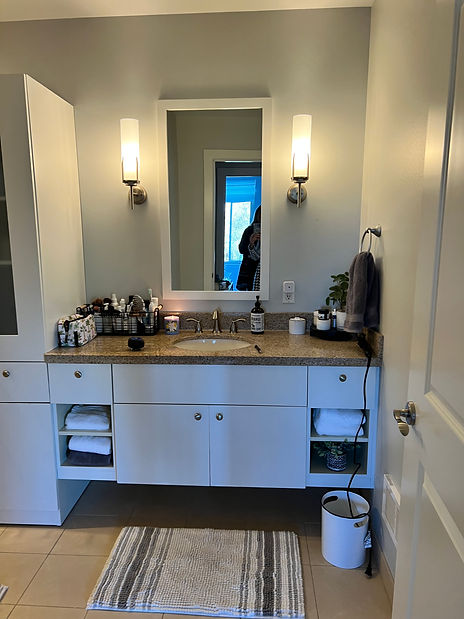 a bathroom with granite countertop and white cabinets
