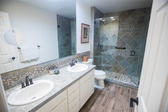 a remodeled bathroom featuring a large mirror and double vanity
