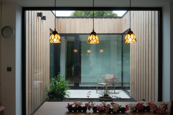 De patio van deze woning, ontworpen door Pierrick Architect, vormt het kloppende hart van de leefruimte. Een verborgen oase die rust en harmonie brengt in het dagelijkse leven. De doordachte vormgeving nodigt de natuur uit om de binnenruimte te omarmen, terwijl de architectuur en de natuurlijke elementen in perfecte harmonie samensmelten. De patio, als een levendig schilderij van licht en schaduw, creëert een serene plek waar de grenzen tussen binnen en buiten vervagen.