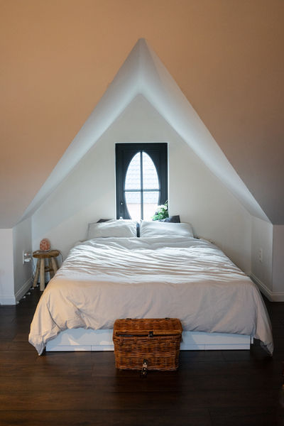 
ChatGPT
Welkom in de intieme slaapkamer onder het dak, een betoverende oase van rust in het landelijke woongedeelte met een karakteristieke dakkapel die het natuurlijke licht elegant binnenlaat. Deze sfeervolle ruimte, gelegen op de dakverdieping onder het beschermende zadeldak, ademt de charme van landelijk wonen uit.

De dakkapel, als een 'ossenoog' naar de buitenwereld, dient niet alleen als een architectonisch element maar ook als een praktische toevoeging die de kamer verrijkt met daglicht en een panoramisch uitzicht op de omgeving biedt. Het zachte gloeien van zonnestralen die door de dakkapel binnenkomen, vult de kamer met een warme en uitnodigende gloed, waardoor een harmonieuze verbinding met de natuurlijke omgeving ontstaat.

Het interieur van deze slaapkamer onder het dak weerspiegelt de essentie van landelijk wonen. Zachte, natuurlijke kleuren en materialen creëren een rustgevende atmosfeer, terwijl de houten balken die het zadeldak ondersteunen, een gevoel van authenticiteit en karakter toevoegen aan de ruimte. Subtiele decoratieve elementen, zoals landelijke textielaccenten en rustieke meubelstukken, dragen bij aan de warmte en gezelligheid van de slaapkamer.

In deze serene omgeving, ondergedompeld in landelijke elegantie, wordt de slaapkamer onder het dak een toevluchtsoord waar men kan genieten van een welverdiende nachtrust. De combinatie van het knusse interieur, de charmante dakkapel en de landelijke esthetiek maakt deze ruimte tot een plek waar comfort en stijl hand in hand gaan, en waar de eenvoud van het landelijke leven wordt omarmd met een eigentijdse touch.