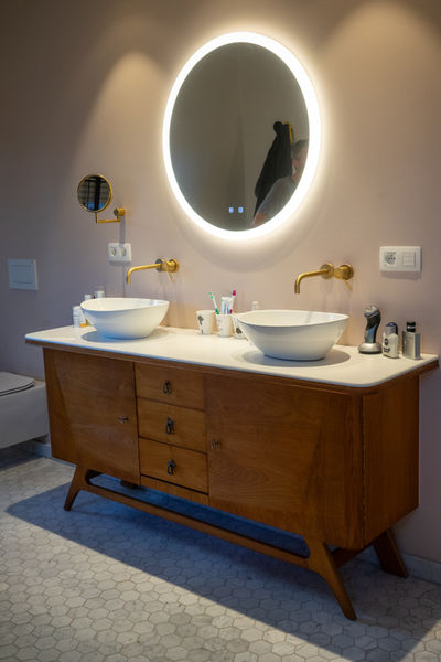 
ChatGPT
Welkom in de badkamer van deze charmante landelijke woning in Bornem, ontworpen door Pierrick Architect uit Temse. Hier is een bijzondere sfeer gecreëerd door slim gebruik te maken van een vintage meubel, omgetoverd tot een eigentijds badkamermeubel met opbouw handwassers.

De badkamer weerspiegelt de tijdloze elegantie van de woning en biedt een unieke mix van oud en nieuw. Het vintage meubel brengt een warme, nostalgische touch, terwijl de moderne opbouw handwassers zorgen voor eigentijds comfort. De ruimte is doordacht ingericht met oog voor zowel stijl als functionaliteit, net zoals de rest van de woning.

In deze badkamer is elk detail met zorg gekozen, wat resulteert in een tijdloze en praktische uitstraling. Net zoals de woning vloeiend overgaat van binnen naar buiten, integreert de badkamer naadloos praktisch ontwerp met esthetische finesse. Het is een plek die perfect past bij de wensen van de bewoners, een harmonieuze toevoeging aan het geheel.

Deze landelijke woning, gelegen in het rustige Wintam, Bornem, wordt vastgelegd in prachtige foto's door Rebecca Tanghe Fotografie.