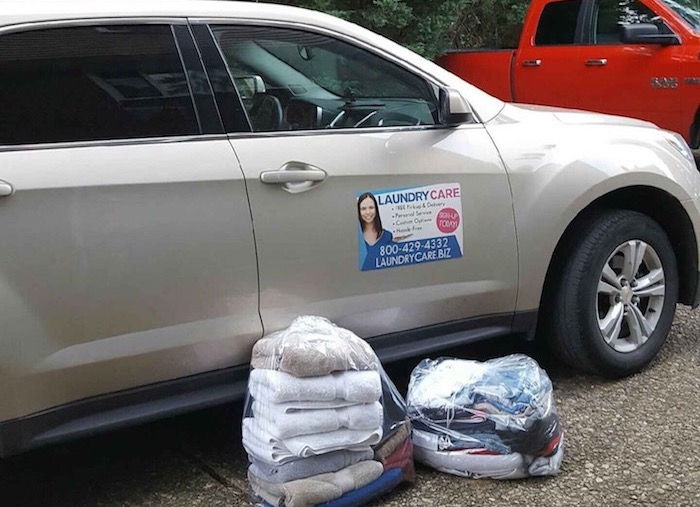 Laundry Care delivery vehicle parked near bags of clean laundry