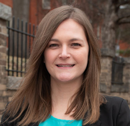 headshot: woman with straight, light brown hair wearing a turquoise top with a black jacket