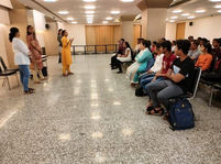 A facilitator addressing a group of young adults during an interactive workshop focused on soft skills and emotional awareness in a community hall setting.