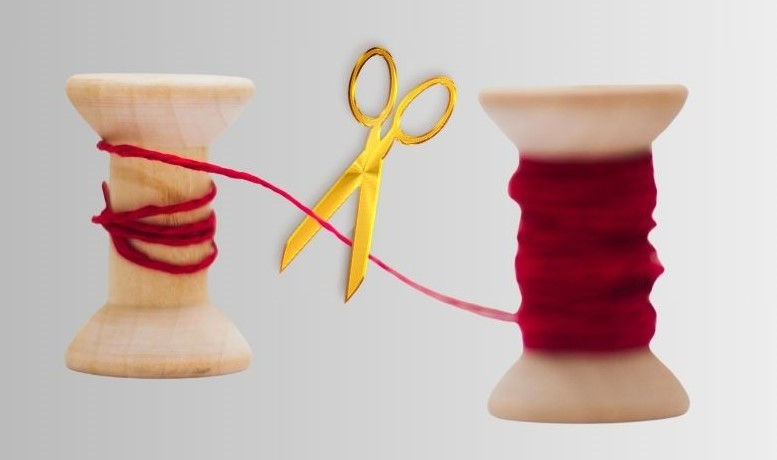 2 Garnrollen miteinander durch den Faden verbunden und eine Schere