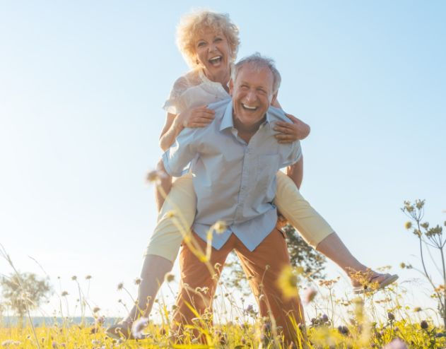 Freude und Übermut - ein Mann mit einer Frau im Huckepack