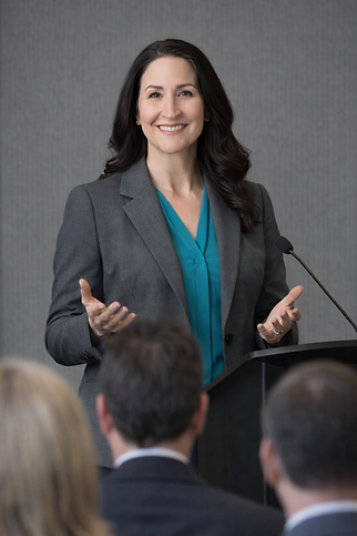 Dr. Harms at a podium speaking in front of an audience.