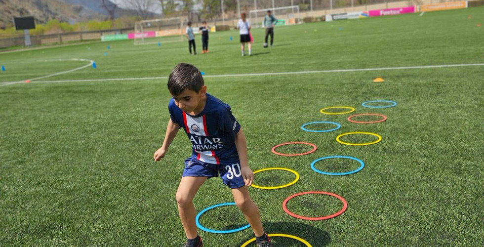 A boy runs through an obstacle course with hoops
