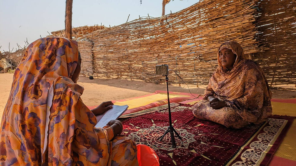 Two women sitting down for a video interview with a mobile phone