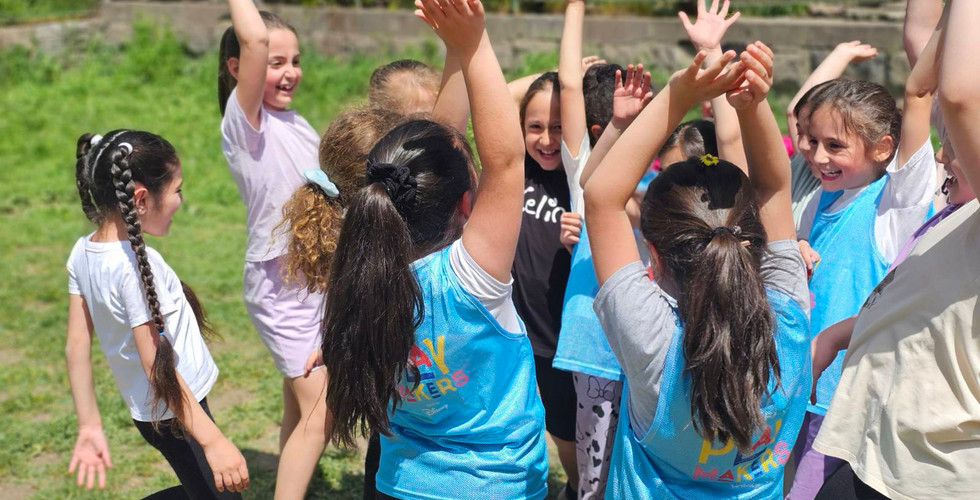 a young soccer team cheers with their hands in the air