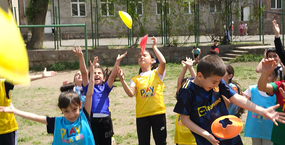 young soccer players throw cones in the air