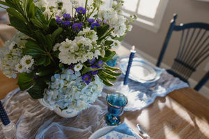 Candle lit evening dinner with vintage blues, layered florals, afternoon light