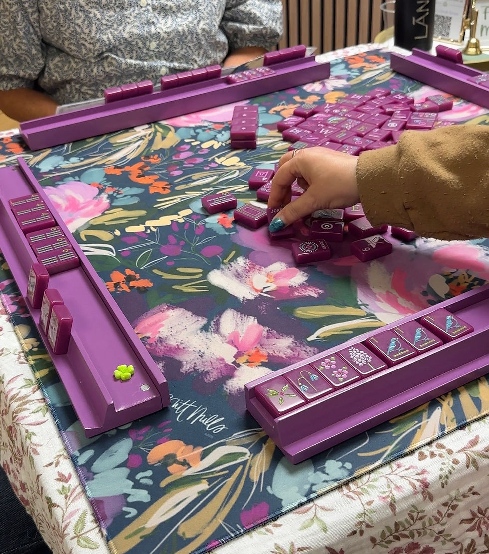 Mah Jongg Game in progress with beautiful Plum-colored tiles from Woodlands Mahjong Society in their Seasons collection. Mat by Britt Mills; racks by Peace Love Mahjong.