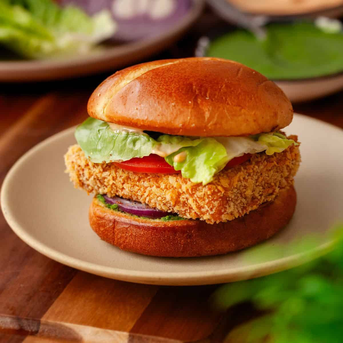 Crispy fish burger on a bun with lettuce and tomato