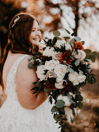 Smiling bride holding large wedding bouquet